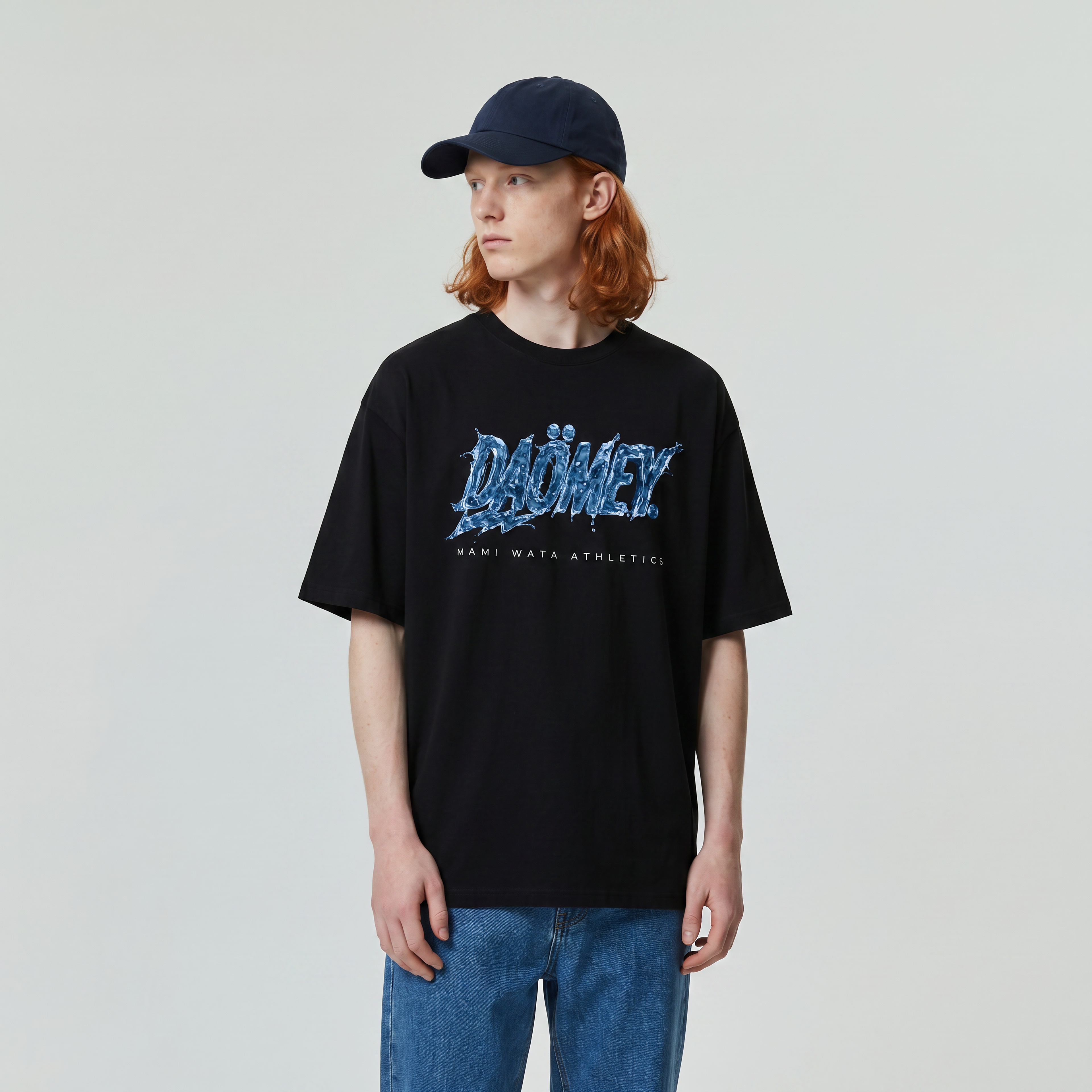 Person wearing a black t-shirt with blue text and a cap on a plain background