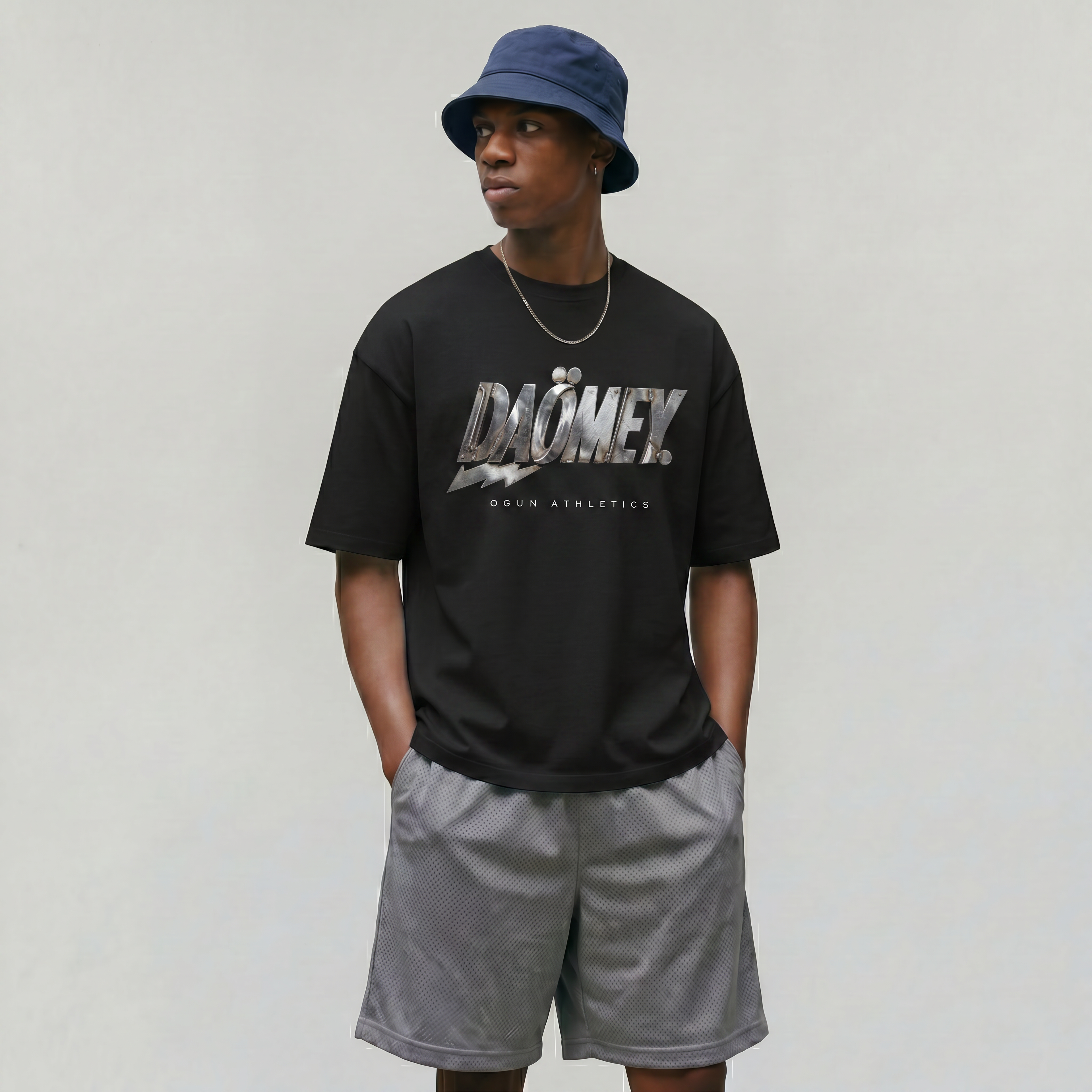 Person wearing a black t-shirt with 'DAOMEN' branding, gray shorts, and a blue bucket hat on a plain background.