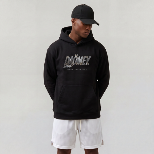 Person wearing a black hoodie with 'DOMEX' branding and white shorts on a plain background